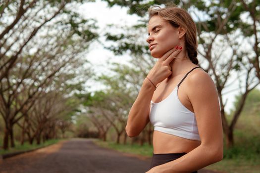 woman checking pulse after running in the forest. bali