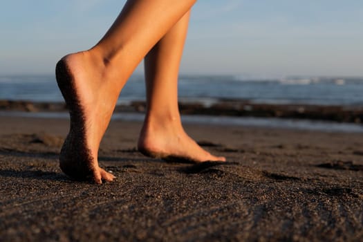 close-up. feet on black sand beach. bali