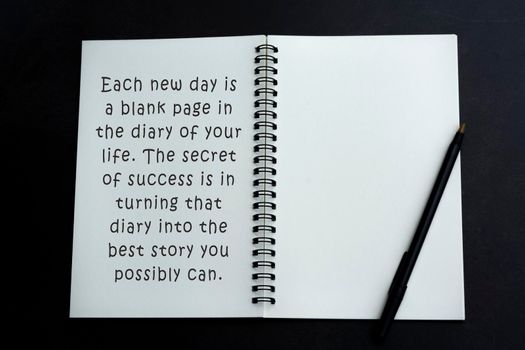 Motivational and inspirational quote on white notebook over dark background