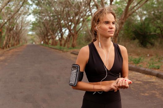 woman in black sportwear checking pulse after running. bali