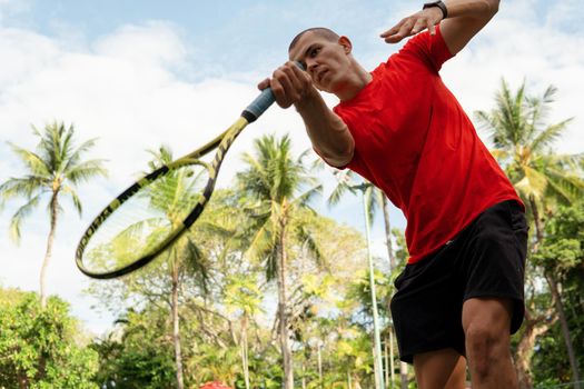 man in red sportwear playing tennis. bali