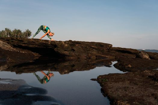 beautiful woman doing yoga on the beach. bali