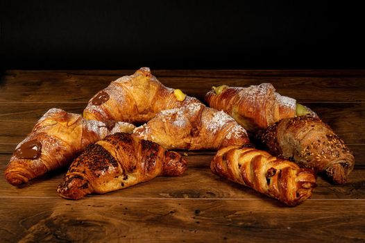sweet croissants with mixed creams on a wooden surface