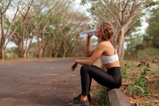 woman drinking water in the park. bali