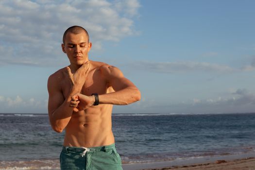 a man checks his pulse after training. bali