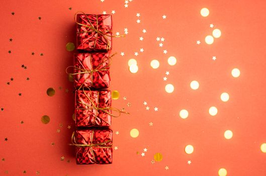 Red Christmas gifts and Christmas trees on a red background. An article about the New year and Christmas. The choice of gifts. A red gift . New Year's background