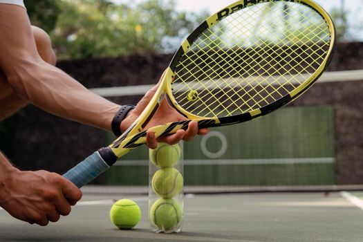 close-up. male hands holding tennis racket and balls. bali