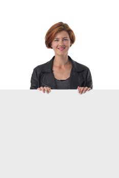 Redhead pretty young woman holding large blank white sign in front of her isolated on white background