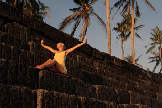 beautiful woman posing on the black stones. bali