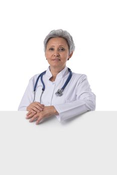 Mature asian doctor woman showing blank billboard, isolated on white background