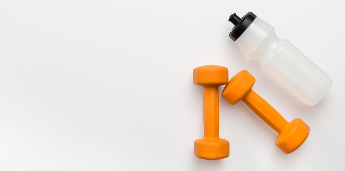 flat lay orange weights with water bottle copy space. High resolution photo