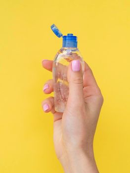front view hand holding plastic bottle with hand sanitizer. High resolution photo