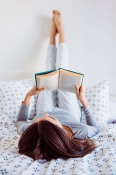 young woman reading bed. High resolution photo
