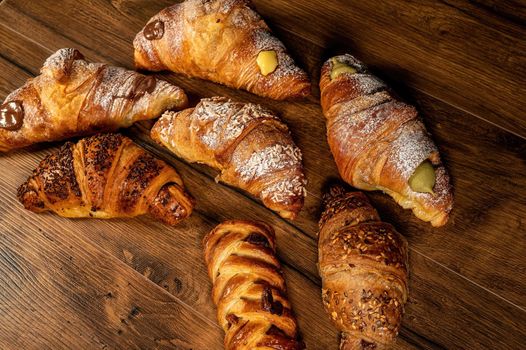 sweet croissants with mixed creams on a wooden surface