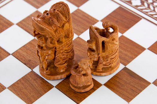 Three Indian sandalwood chess pieces on a board
