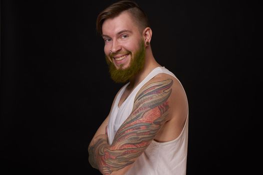 stylish bearded man in a white t-shirt with tattoos on his arms fashion. High quality photo