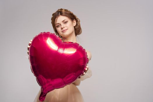 cheerful woman in a dress balloon Valentine's Day model studio. High quality photo