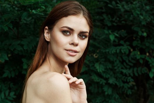 portrait of a woman in a field outdoors bare shoulders clear skin cropped view. High quality photo