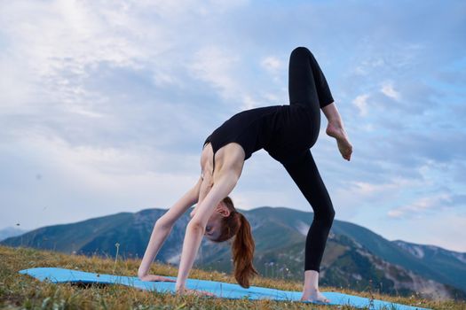 sportive woman workout meditation in the mountains outdoors. High quality photo