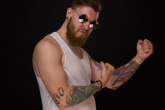 bearded macho man in white t-shirt sunglasses fashion tattoos. High quality photo