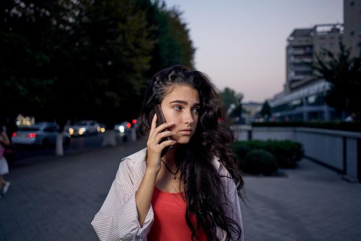 cheerful woman walking on the street talking on the phone. High quality photo