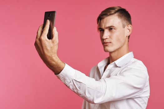 handsome man with a phone in hand fashion posing isolated background. High quality photo