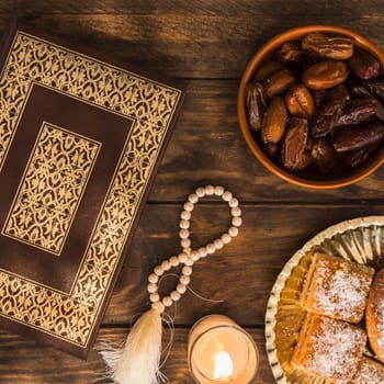desserts candle near beads quran. High resolution photo