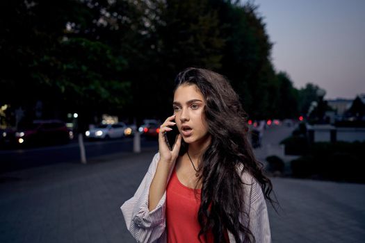 cheerful woman walking on the street talking on the phone. High quality photo