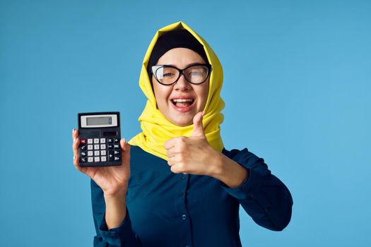woman in yellow hijab technology calculator work finance. High quality photo