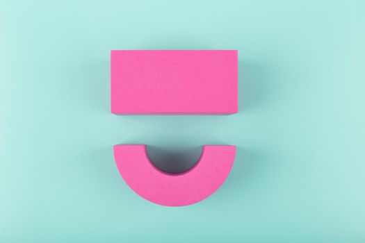 Creative flat lay with pink happy smile symbol made of figures on blue background with copy space. Concept of Smile day, emotions, emoji or mental health