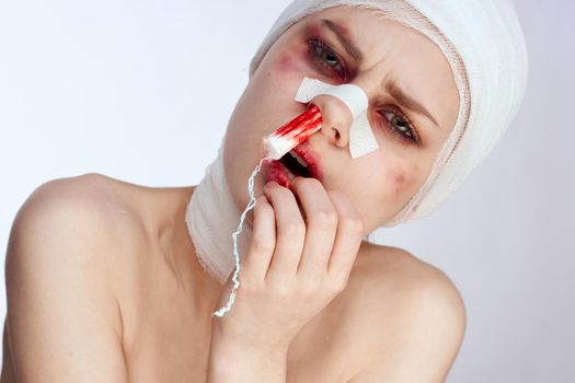 female patient tampon in the nose with blood injured face isolated background. High quality photo