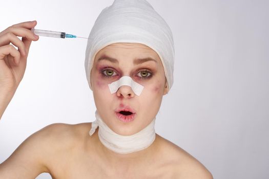 emotional woman bandaged face the syringe sticks out in the head light background. High quality photo