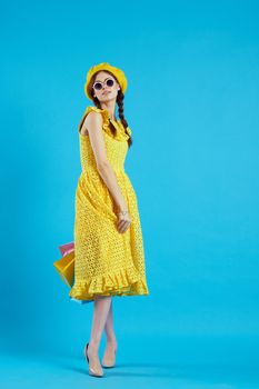 cheerful woman in a yellow hat Shopaholic fashion style studio model. High quality photo