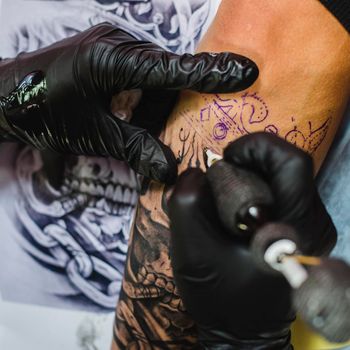 hands gloves doing tattoo. High resolution photo