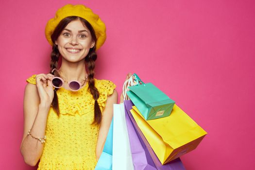 glamorous woman in a yellow hat Shopaholic fashion style pink background. High quality photo