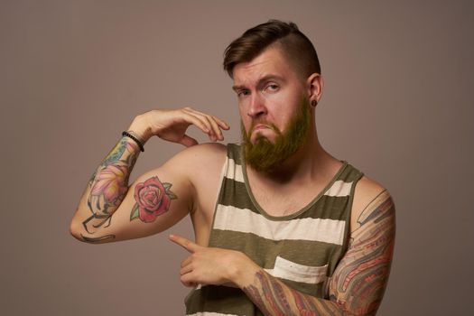 handsome man with tattoos on his arms fashionable hairstyle emotions. High quality photo