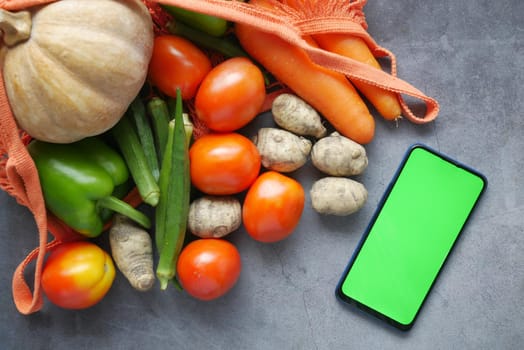 top view of smart phone with fresh vegetable on table .