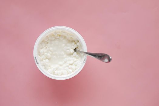 cottage cheese in a bowl on pink background .