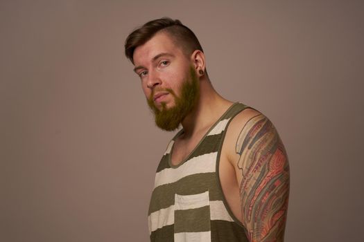 handsome man with tattoos on his arms fashionable hairstyle emotions. High quality photo