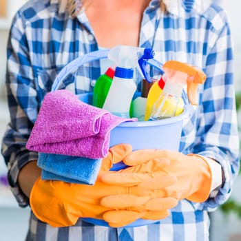 mid section woman holding cleaning equipments blue bucket. High resolution photo