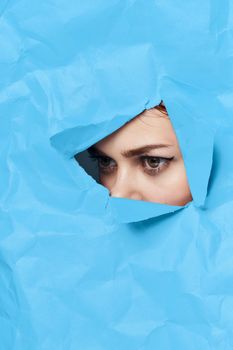 woman's face breaks through blue mockup close-up. High quality photo