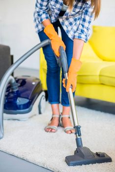 close up woman s hand cleaning carpet with vacuum cleaner. High resolution photo