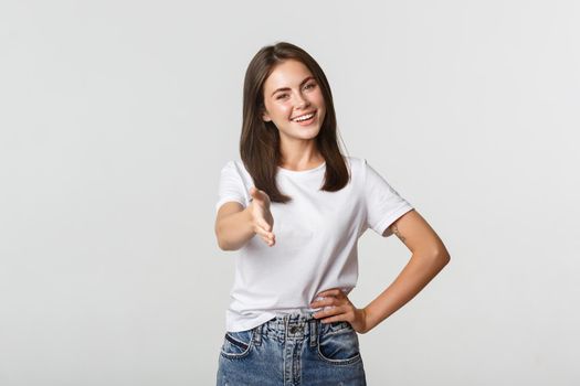 Smiling confident young woman extend hand for handshake, greeting person.