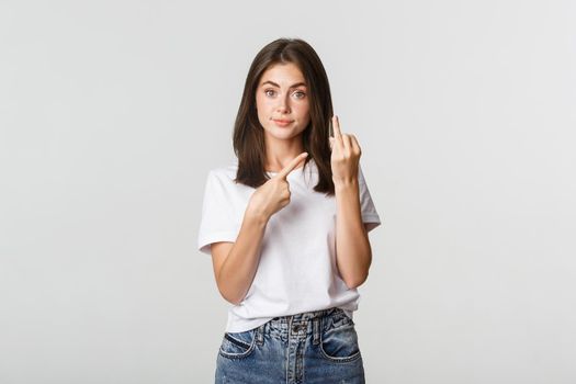 Displeased brunette girl complaining to boyfriend, pointing at finger without wedding ring.