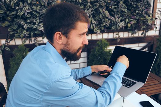 business man outdoors with laptop in cafe emotions. High quality photo