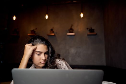 woman sitting in a cafe in front of a laptop communication technology internet. High quality photo