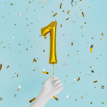 white hand holding a balloon with the number 1 and golden confetti falling down. birthday celebration. 3d render