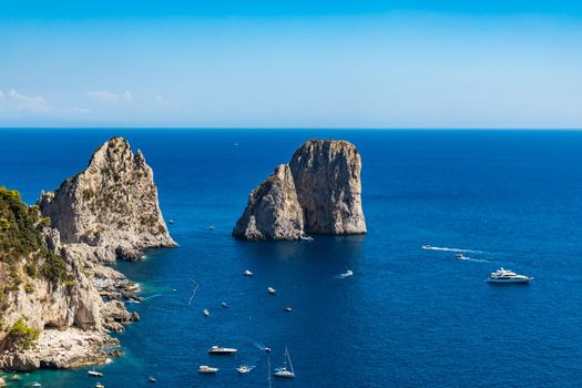 Beautiful panorama of small bay full of small ships and boats next to 
Faraglioni di Mezzo
 and Capri island 