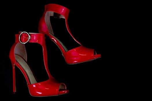 red patent leather sandal for the summer season on a black background