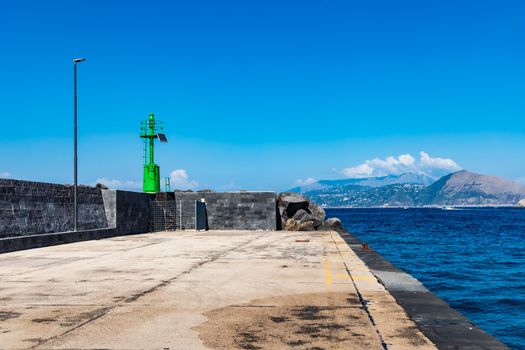 End of small breakwater with pier in bay of Capri island